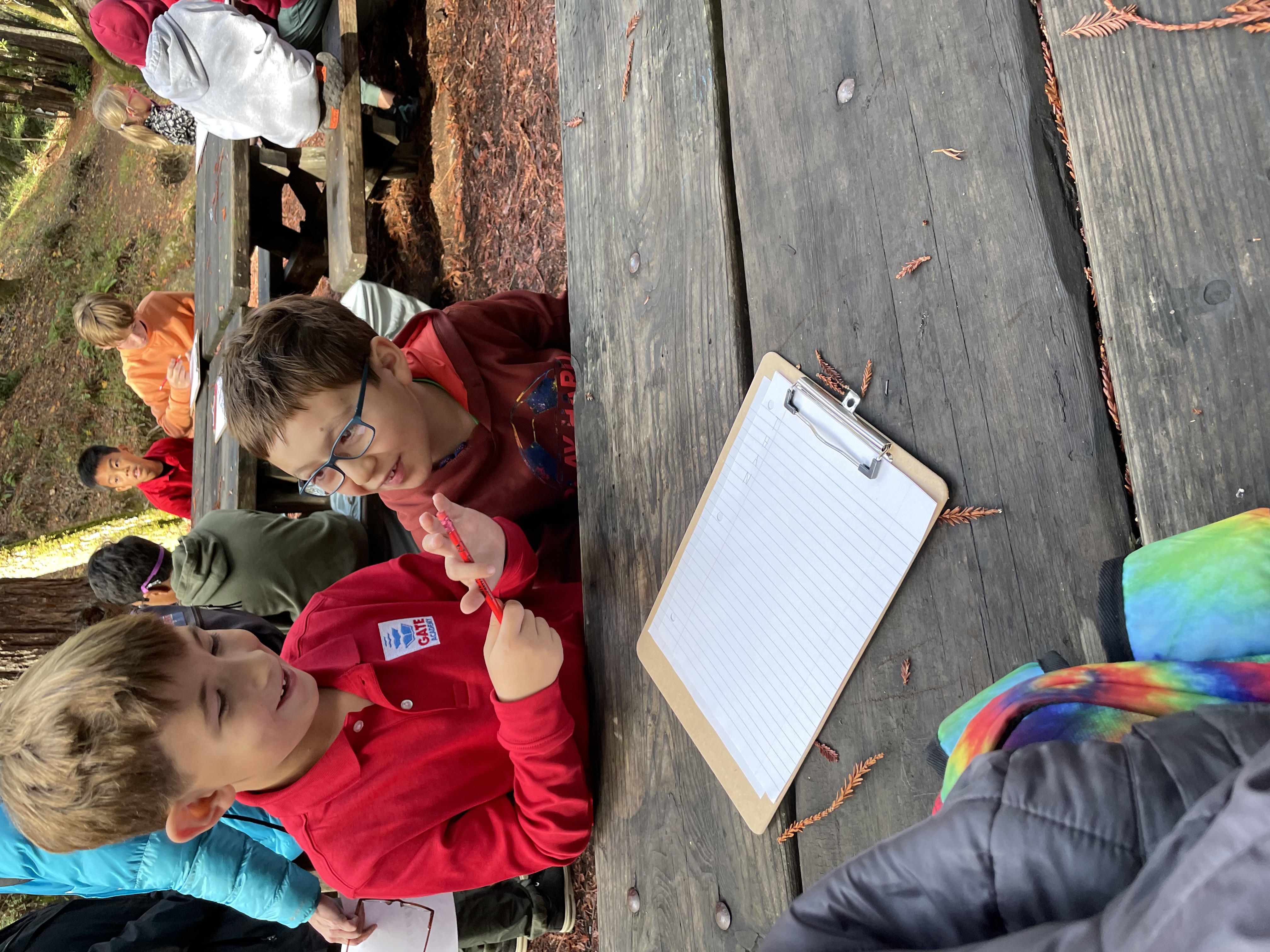 Two GATE students talking over their work at an outdoor table