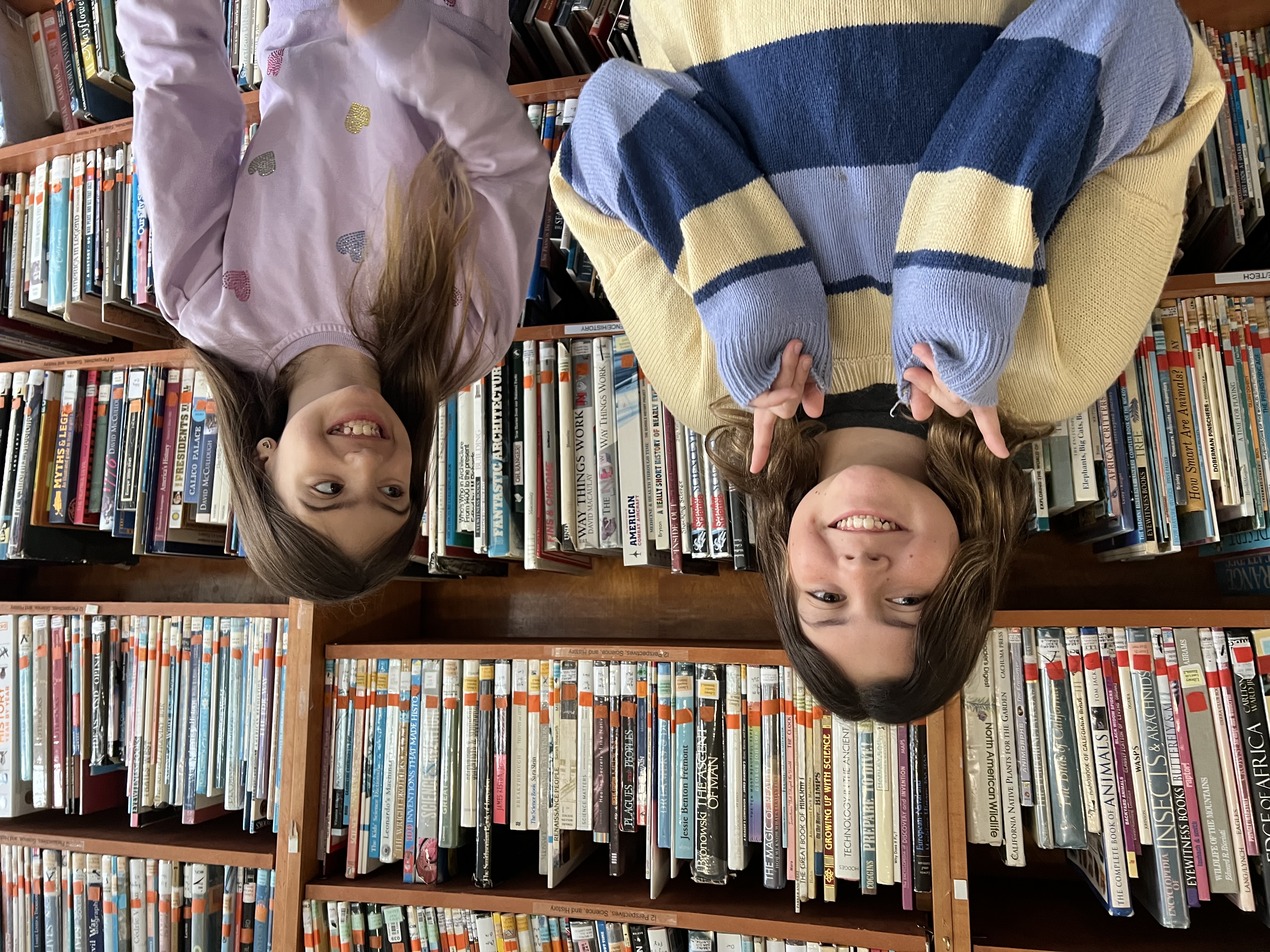 Two GATE students laughing together in the school library
